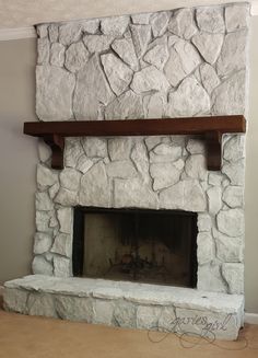 a stone fireplace in a living room next to a wall