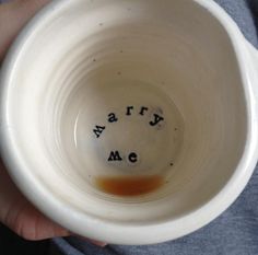 a person holding a white cup with the word army on it