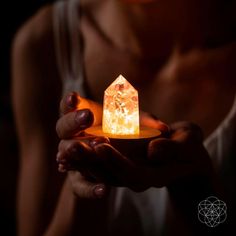 a person holding a glowing object in their hands, with the light shining on them