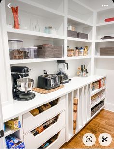 a kitchen with white cabinets and shelves filled with appliances