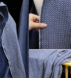 a woman is holding up a blue blanket with white piping on it and the bottom half