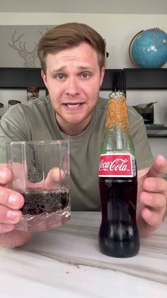 a man sitting at a table with a bottle and two glasses in front of him