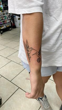 a person with a bird tattoo on their arm