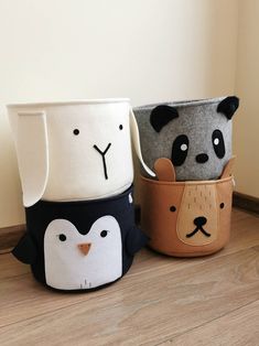 three small pots with animals on them sitting next to each other in front of a wall