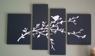 four pieces of black and white art with birds on branches in the middle, against a gray wall