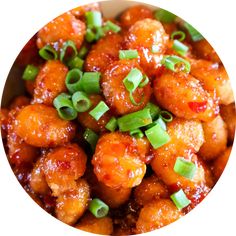 a bowl filled with meat covered in sauce and green onions