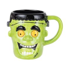 a green mug with a creepy face on it