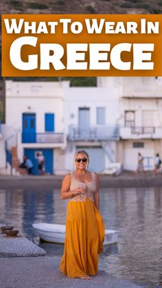 a woman standing in front of a body of water with the words what to wear in greece