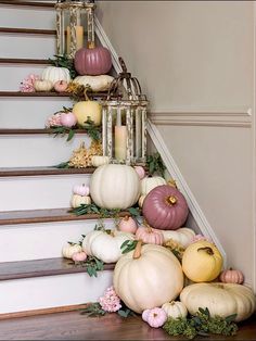 a staircase decorated with pumpkins and greenery