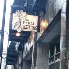 the sign for the farm house restaurant is hanging from the side of an old building