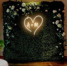 a white cake sitting on top of a table next to a green wall with a heart