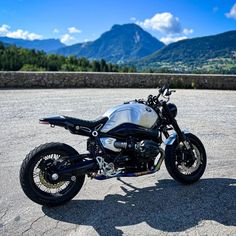 a motorcycle parked on the pavement in front of mountains