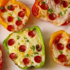 someone is holding a pepperoni and cheese stuffed bell peppers on a white platter