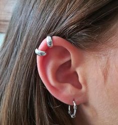 a woman's ear is shown with two piercings