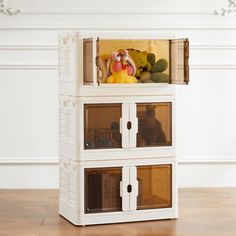 a doll house with three drawers and stuffed animals in the top one is white, while the other two are brown