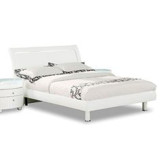 a white bed sitting next to a night stand