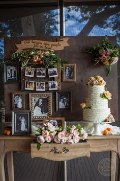 a wedding cake sitting on top of a wooden table next to pictures and framed photos