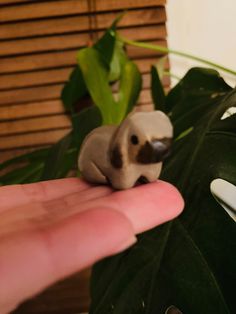 a small elephant figurine sitting on top of a palm leaf next to a window