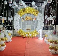 balloons and streamers are set up on the floor for a birthday party with white, gold and silver decorations