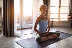 a woman is sitting in a yoga pose