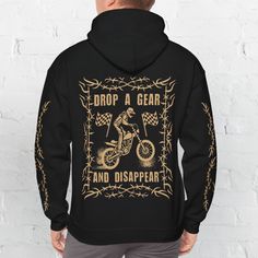 a man wearing a black hoodie that says drop a gear and disappear