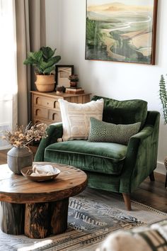 a living room with green velvet couches and coffee table in front of a painting