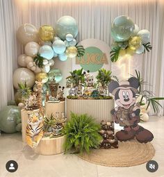 a room filled with lots of balloons and plants on the floor next to a wall