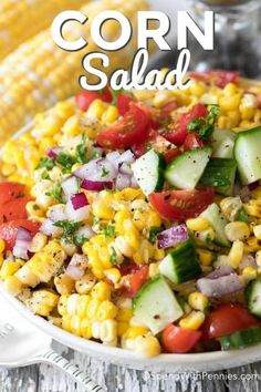 corn salad in a white bowl with cucumbers and tomatoes