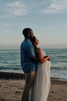 a man and woman embracing on the beach