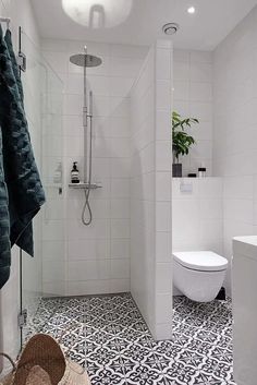 a white bathroom with black and white floor tiles