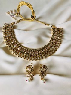 This dainty light pink choker necklace, adorned with intricate Kundan work, delicately complements your neckline. Paired with elegant earrings, this minimalistic set captures the essence of refined beauty and simplicity. Ideal for those who appreciate the charm of subtlety, this Kundan jewelry set seamlessly blends traditional elements with contemporary aesthetics. Whether you're attending a special Desi event or seeking a timeless piece for your collection, our Gold and Light Pink Choker Necklace Set is a perfect choice designed to infuse sophistication into your style. Pink Choker Bridal Necklace Gift, Pink Bridal Choker Necklace As Gift, Pink Necklaces With Intricate Design For Gift, Pink Choker Necklace For Celebrations, Elegant Pink Choker For Festive Occasions, Pink Kundan Choker Necklace, White Choker With Intricate Design For Gift, Pink Choker Necklace, Desi Jewelry