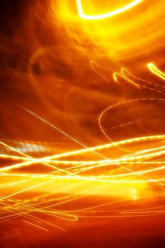 blurry photograph of street lights in the night with orange and yellow light from cars