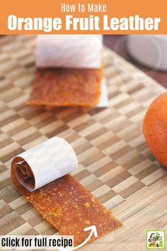 an orange sitting on top of a wooden cutting board next to a roll of paper