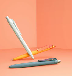 an orange and white pen sitting on top of a pink surface