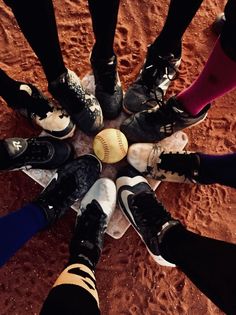 a group of people standing in a circle with their feet on a baseball