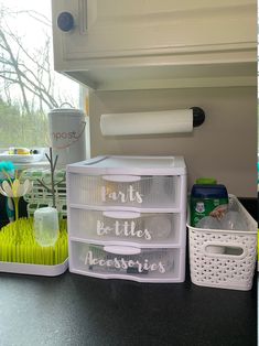 some plastic containers are sitting on the counter next to plants and other items that have been placed in them