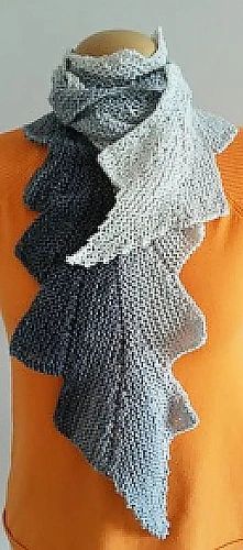 a mannequin wearing an orange shirt and black and white scarf on it's neck