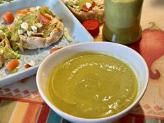 a bowl of soup next to a plate of food