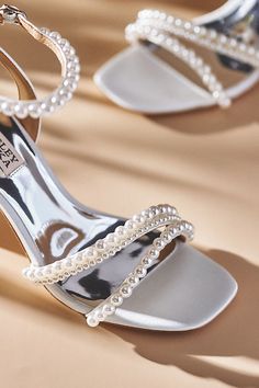 two pairs of high heeled shoes with pearls on the toes and heels are sitting next to each other