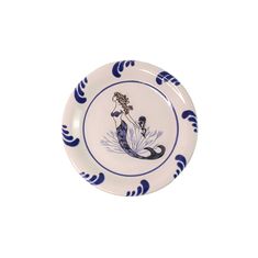 a blue and white plate with an image of a mermaid sitting on it's side