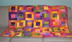 a couch with a colorful quilt on it