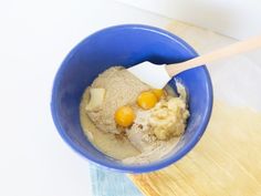 a blue bowl filled with food on top of a wooden cutting board