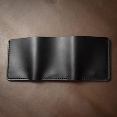 This is a substantial leather trifold wallet.When you're out for dinner with friends, they will notice when you throw this wallet on the table. A loud thud followed by eyes fixed on this beautifully constructed piece will make an impression. Immaculate hand-stitching and full-grain Horween leather compliment a smartly designed, but hefty wallet.This full-grain Horween leather wallet is designed to hold a lot of cards and a lot of cash. Easily flip out your ID when it's needed and the wallet will Black Bifold Wallet With Interior Card Slots, Black Bifold Wallet For Daily Use, Black Bifold Wallet For Everyday Use, Black Trifold Card Holder For Daily Use, Black Leather Trifold Card Holder, Black Trifold Travel Wallet, Black Trifold Wallet For Travel, Black Trifold Wallet For Daily Use, Everyday Black Trifold Wallet With Smooth Grain