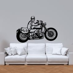 a black and white drawing of a man on a motorcycle wall decal in a living room