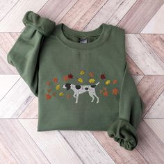 These unisex cozy sweatshirts (we use Gildan) are embroidered with a German Shorthaired Pointer surrounded by fall leaves :)  * 50% cotton, 50% polyester * Pre-shrunk * Classic fit * 1x1 athletic rib knit collar with spandex * Air-jet spun yarn with a soft feel and reduced pilling * Double-needle stitched collar, shoulders, armholes, cuffs, and hem SIZING: Please ensure you check measurement chart before ordering as shirts are printed once you place your order. Sweatshirts are unisex sizes but t Fall Fleece Top With Embroidered Graphics, Green Fleece Sweatshirt For Fall, Embroidered Green Sweatshirt For Fall, Fall Crew Sweatshirt With Custom Embroidery, Fall Crew Neck Sweater With Custom Embroidery, Embroidered Fleece Sweatshirt For Fall, Shorthaired Pointer, Sweater Autumn, German Shorthaired Pointer