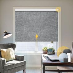 a living room with a couch, chair and window covered in grey fabric roller shades