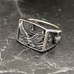 925 Sterling Silver American Eagle Flag Ring , Silver United States Flag Ring , 925 Sterling Silver Liberty Patriotic Ring , Gift For Him , Same Day For Shipping ✧ Product Details * Handmade İtem * Gender : Male / Female * Material : 925K Sterling Silver * Ring Weight : 13 Grams ✔ Usage Details * Silver jewelry is very sensitive to chemicals. It is recommended to keep away from chemical substances such as cream, bleach, deodorant, detergent. * Silver jewelry can also darken quickly in salt water, that is, in sea water. For this reason, it is best to remove them when swimming in the sea. ✔ Shipping * Your orders placed on weekdays are delivered to the cargo on the same day. Your orders placed on the weekend are delivered to the cargo on Monday. ✔ Other Details * Our products are handmade an Rectangular Silver Engraved Ring Stamped 925, Silver Rectangular Engraved Sterling Silver Ring, Rectangular Engraved Sterling Silver Ring In Silver, Rectangular Sterling Silver Rings, Nickel-free Silver Rectangular Rings, Eagle Flag, Chemical Substances, United States Flag, Ring Collections