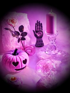 a pink table topped with candles and decorative items