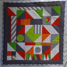 a quilted wall hanging with an abstract design