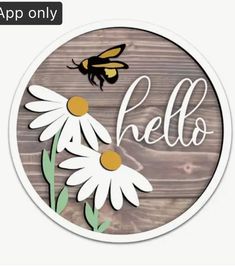 a sticker with the word hello on it and two daisies in front of a wooden